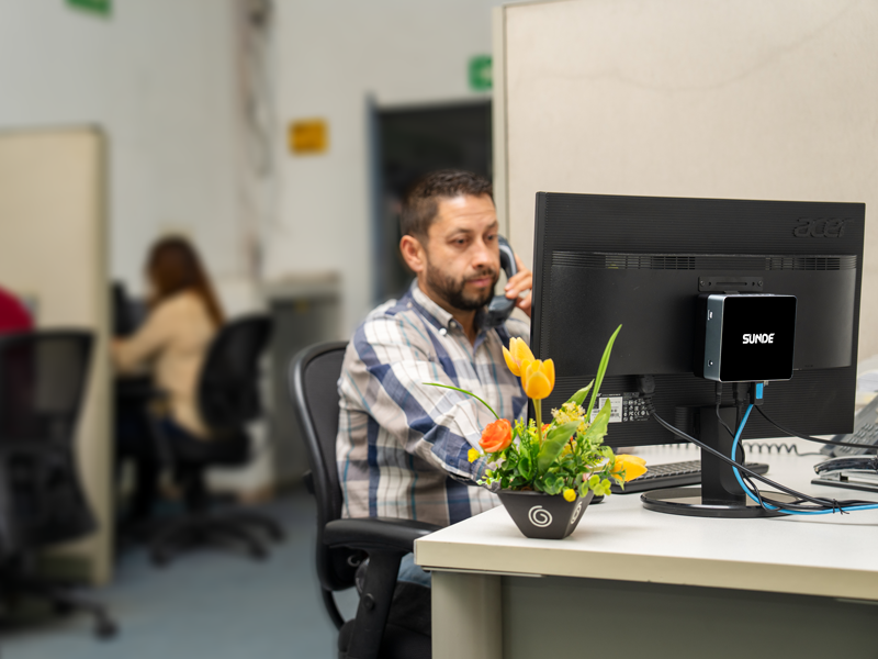 8 MiniPC SD512 montada detrás de un monitor.